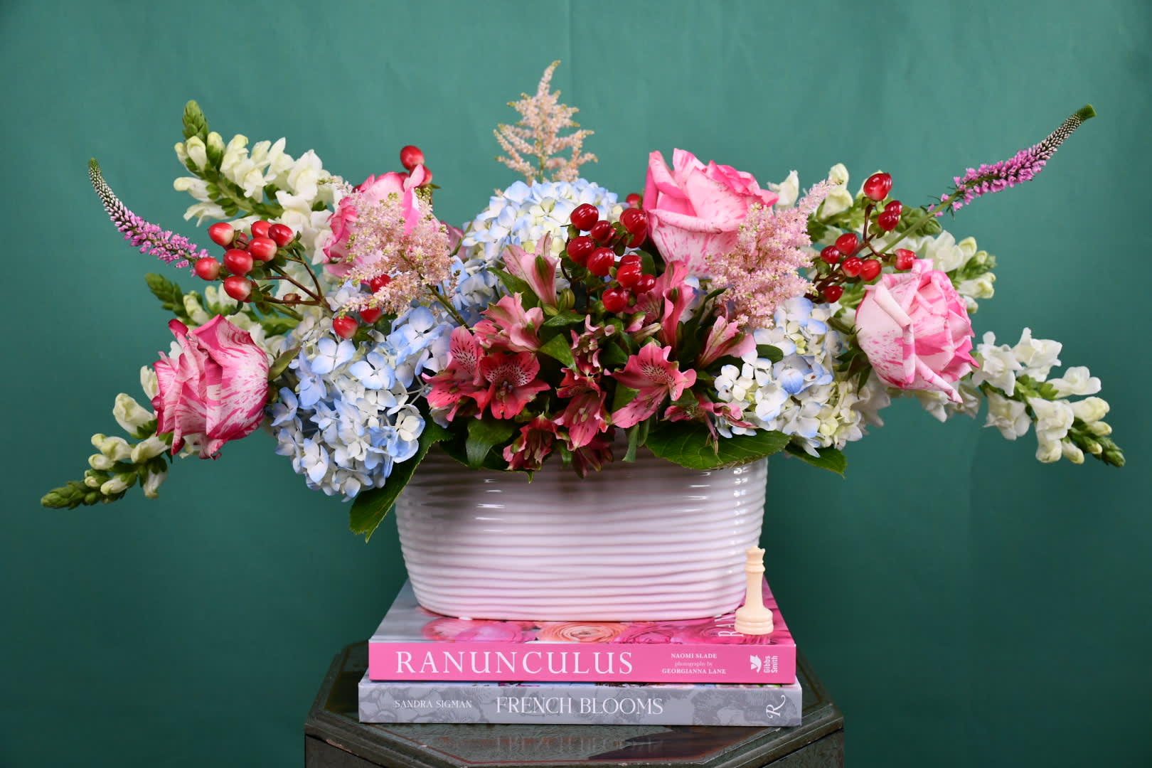 Mixed bouquet in a white ribbed vase with pink, blue, and white flowers