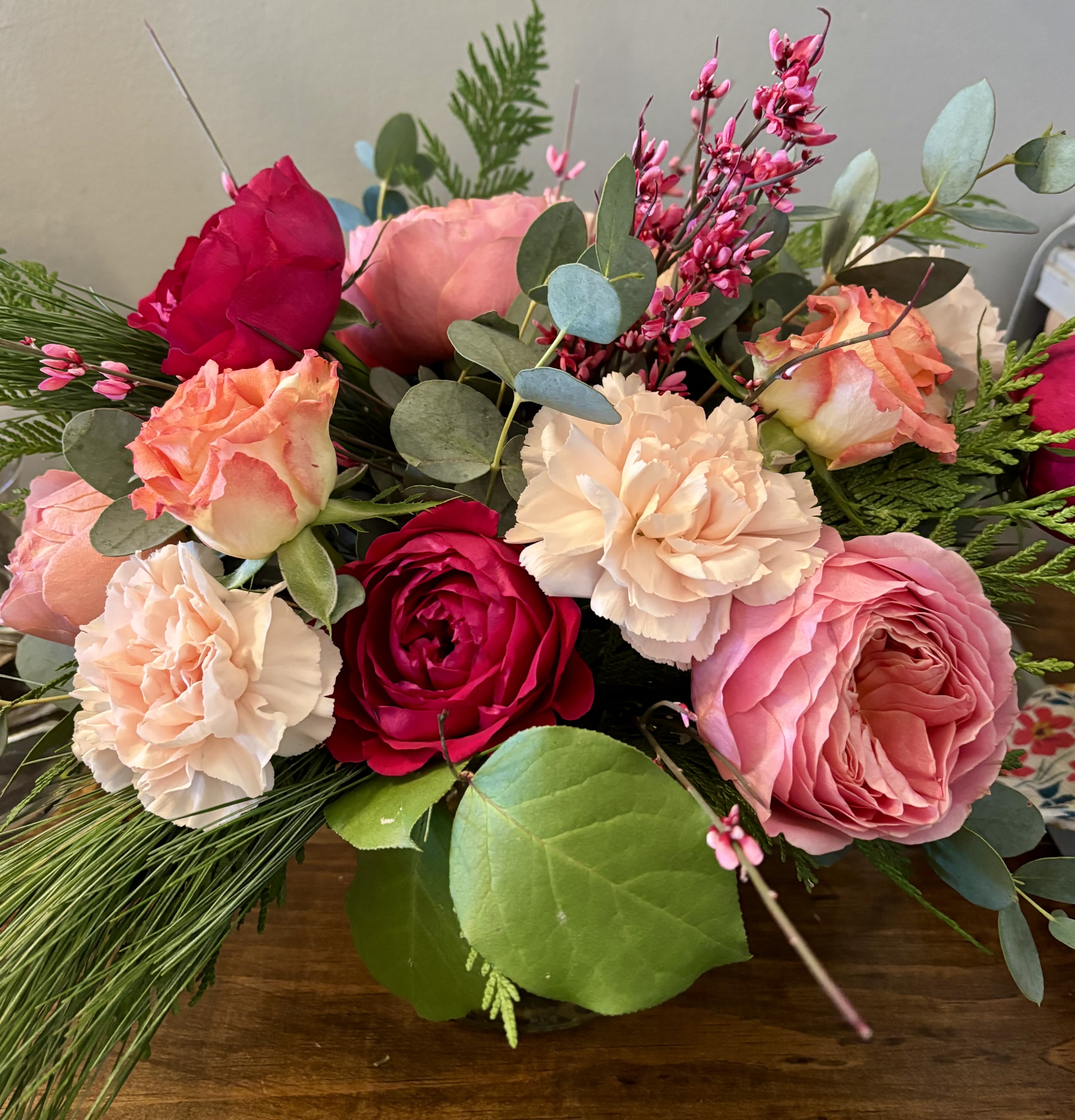 Mixed bouquet of pink and peach roses with carnations and greenery