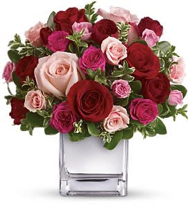 Love Medley Bouquet - Sing her a love song - with flowers. This lush, loving rose arrangement tells her just how much you care. The stylish bouquet features large red and pink roses accented with smaller spray roses in shades of red and pinks. Delicate green oregonia and pittosporum add a fresh contrast, and all comes arranged and delivered in our exclusive Mirrored Silver Cube vase.