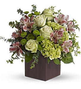 Green and pink floral arrangement in a dark square box