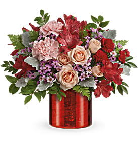 Red and blush floral arrangement in a red vase