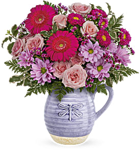 Pink and lavender mixed bouquet in a lavender ceramic pitcher vase
