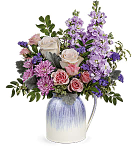 Bouquet of pink and lavender flowers in a blue-and-white pitcher vase