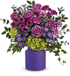 Purple and green mixed bouquet in a purple vase