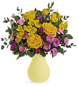 Yellow roses and pink flowers in a pale yellow vase