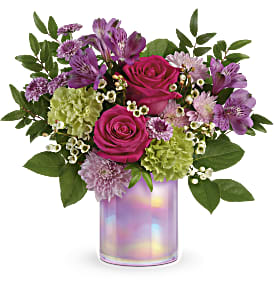 Bouquet of pink roses, purple alstroemeria, and green hydrangeas in a iridescent vase
