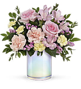 Pink and cream flower arrangement in an iridescent glass vase