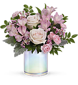 Pink and white flower arrangement in an iridescent glass vase