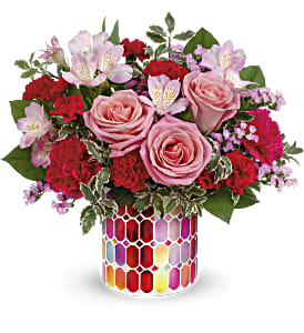 Pink roses and red carnations in a colorful mosaic vase