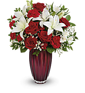 Red roses and white lilies arranged in a tall vase