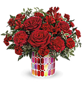 Red roses and carnations in a colorful mosaic vase