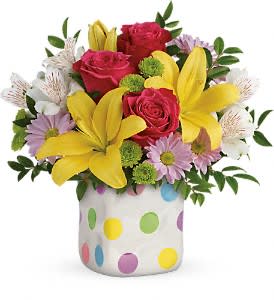 Bouquet of roses, lilies, and daisies in a polka-dot vase