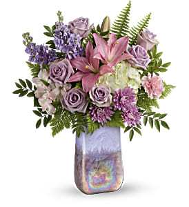 Pink lilies and lavender roses in a tall iridescent vase
