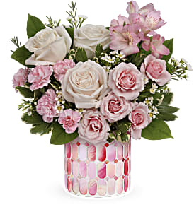 Pink and white roses in a patterned glass vase