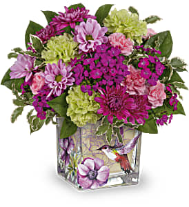 Mixed pink and green flower arrangement in a square glass vase