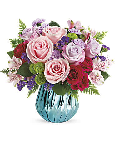 Pink and lavender rose bouquet in a blue glass vase