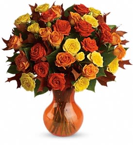 Bouquet of orange, red, and yellow roses in an amber vase