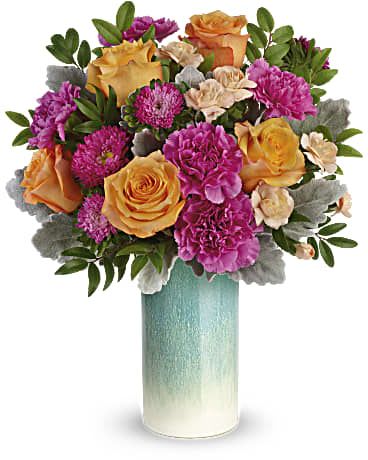 Bouquet of orange and pink flowers in a tall turquoise vase