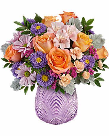 Mixed bouquet of orange roses and purple daisies in a purple vase
