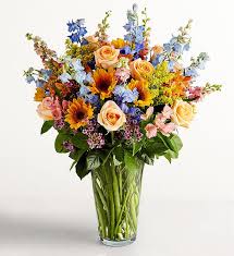 Warm Days Sensation - Bold sunflowers and delphinium, complimented with orange roses and alstroemeria, filled with solidago