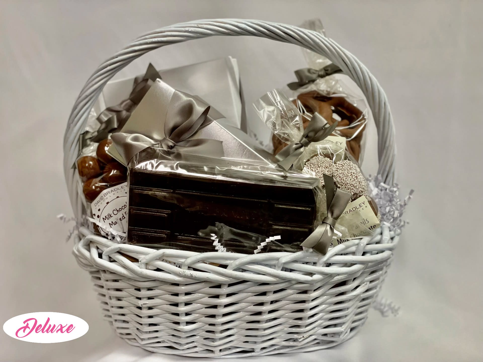 White wicker basket filled with wrapped chocolates and sweets