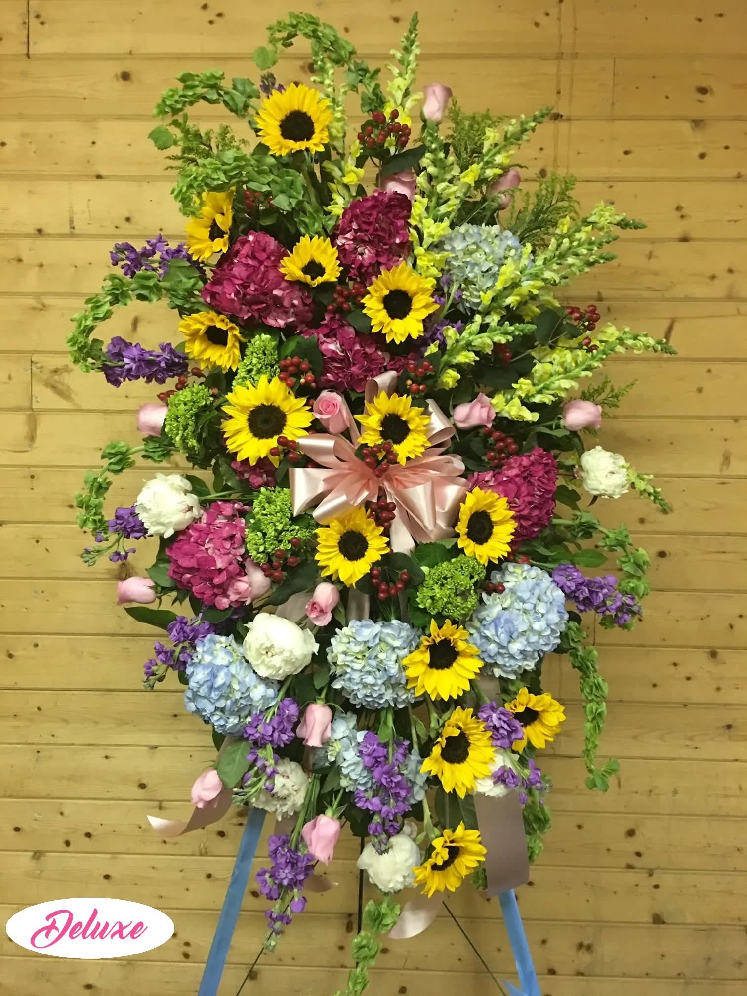 Large standing floral spray with sunflowers, hydrangeas, and ribbon