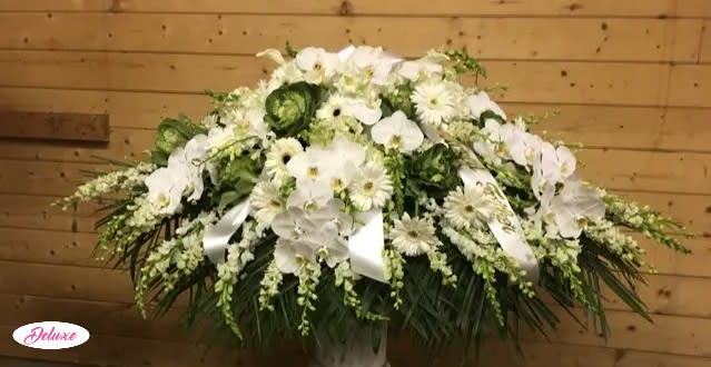  Heavenly Peace  - Heavenly Peace is a graceful casket cover designed to honor a cherished life with serenity, love, and heartfelt remembrance. This elegant all-white floral tribute features beautiful Gerbera daisies, graceful snapdragons, lush hydrangea, and delicate orchids, thoughtfully arranged to create a peaceful and timeless expression of sympathy. The pure white blooms symbolize peace, purity, devotion, and the treasured memories that remain forever in our hearts. Handcrafted by our compassionate florists, Heavenly Peace offers a meaningful way to celebrate a loved one’s life while providing comfort and support to family and friends during a time of loss. A beautiful tribute reflecting grace, tranquility, and everlasting love.