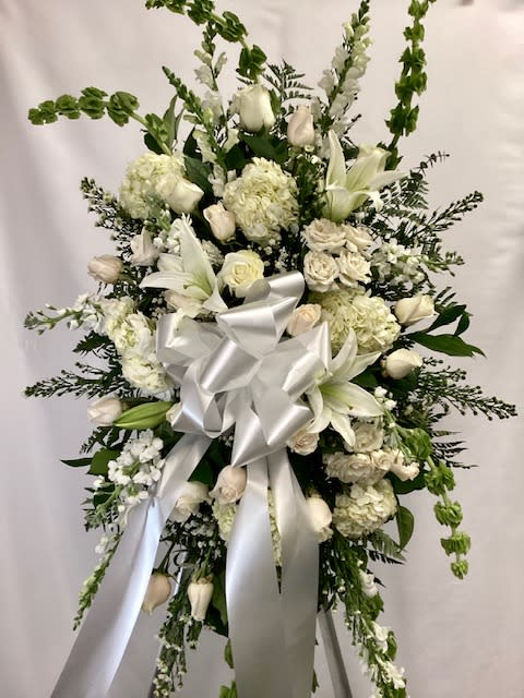 White floral standing spray with a large silver ribbon