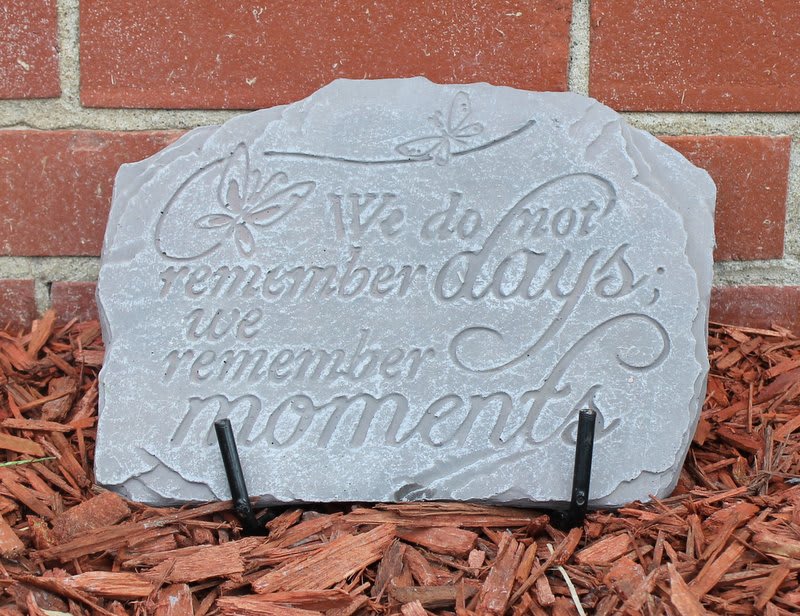 Decorative stone plaque with the words "We do not remember days, we remember moments."