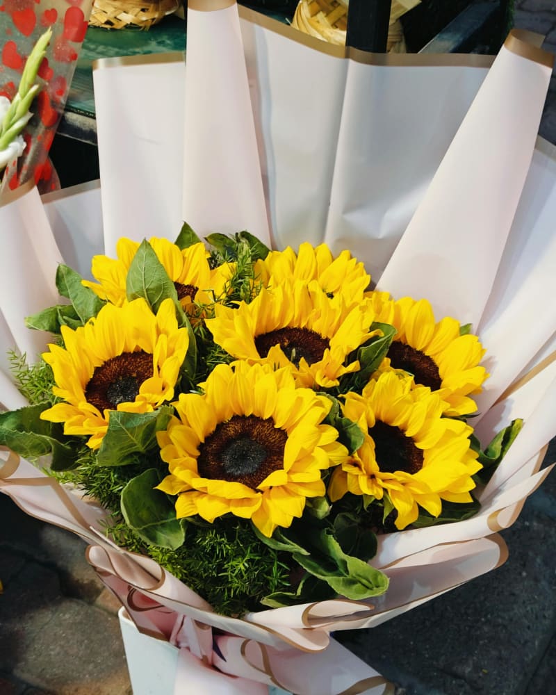 Moss Sunflower Wrap - Enjoy a beautifully wrapped sunflower and mixed green bouquet. Choose from a Half a dozen sunflowers  or one  dozen sunflowers.