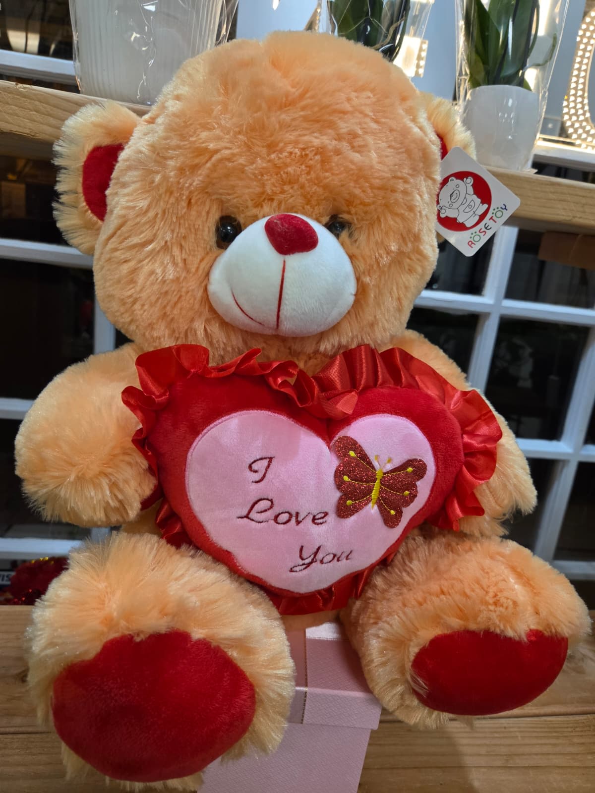 Plush teddy bear holding a heart with "I Love You" text