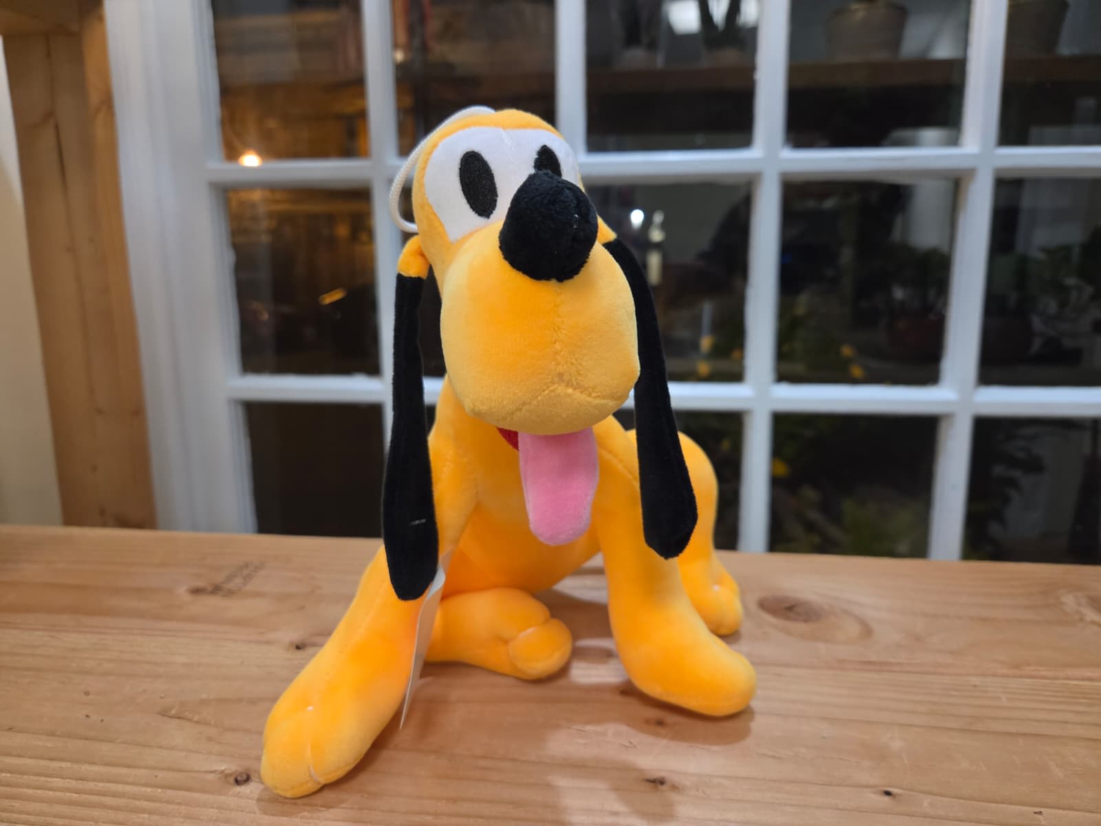 Plush yellow dog with black ears and pink tongue