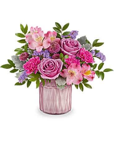 Pink and lavender flower arrangement in a pink glass vase