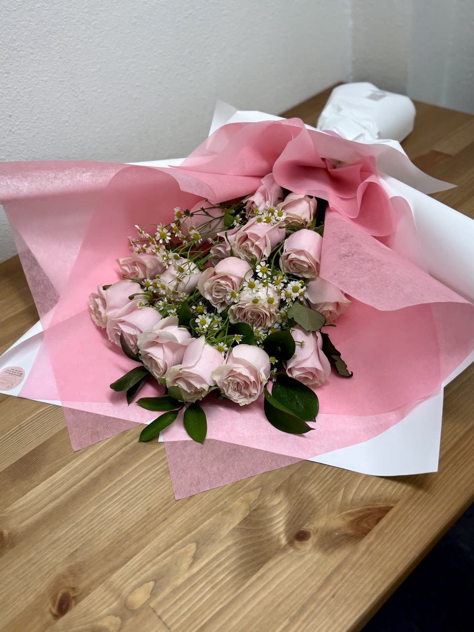 Pink rose bouquet wrapped in pink and white paper