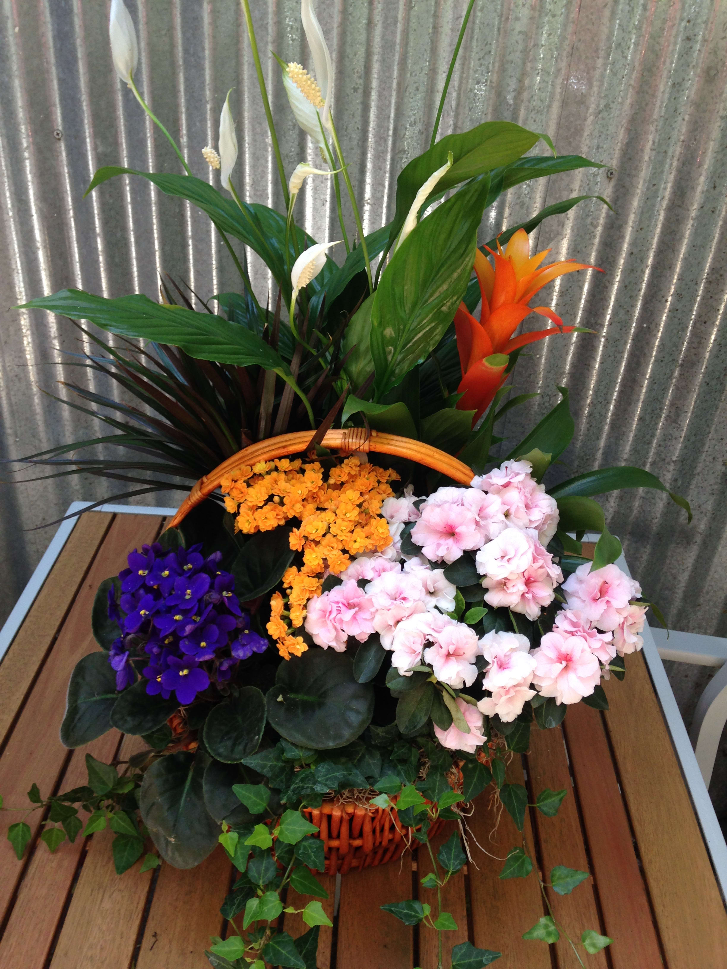 Basket arrangement with pink and purple flowers and tall tropical blooms