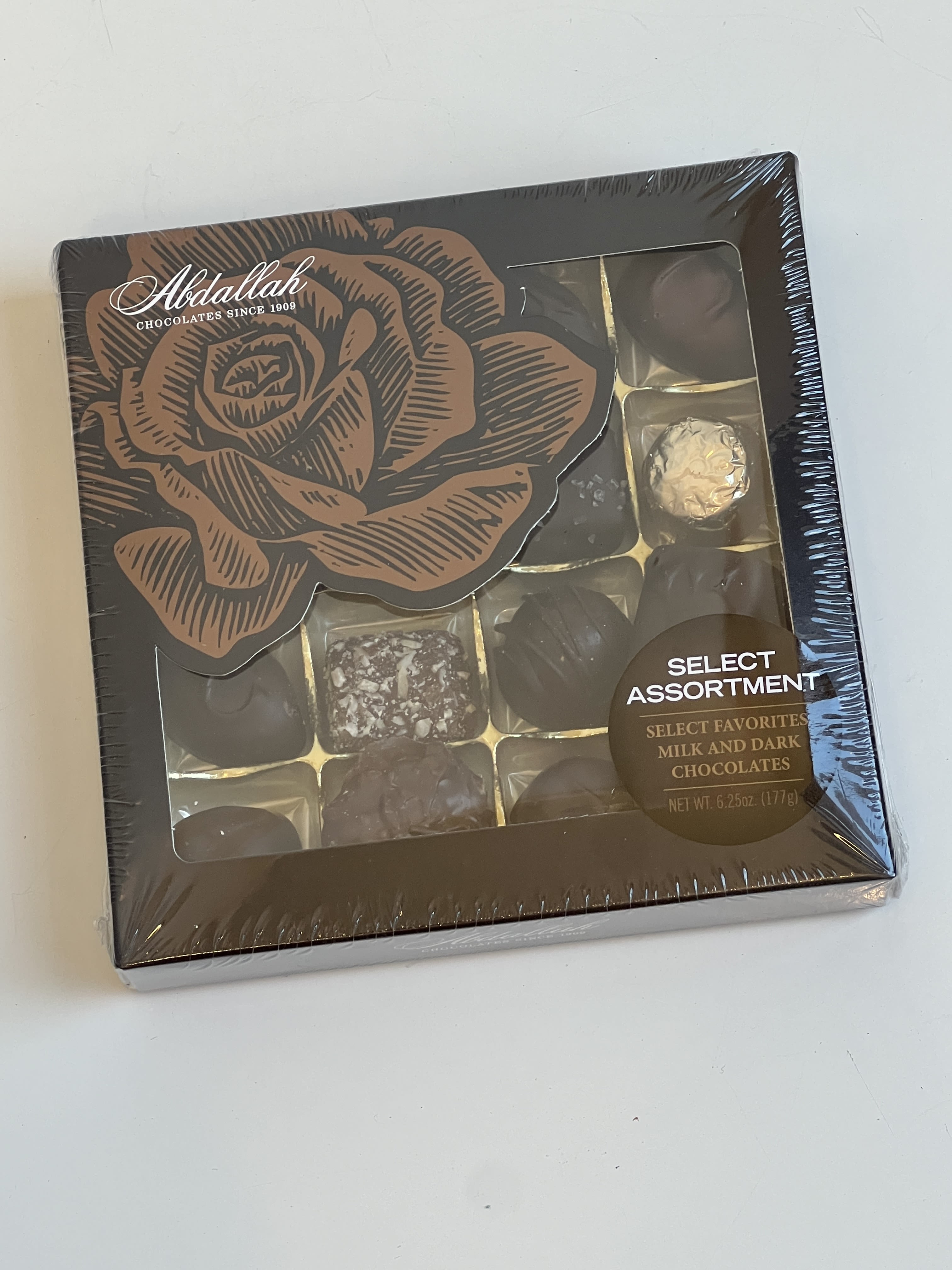 Box of assorted milk and dark chocolates with a rose design on the lid