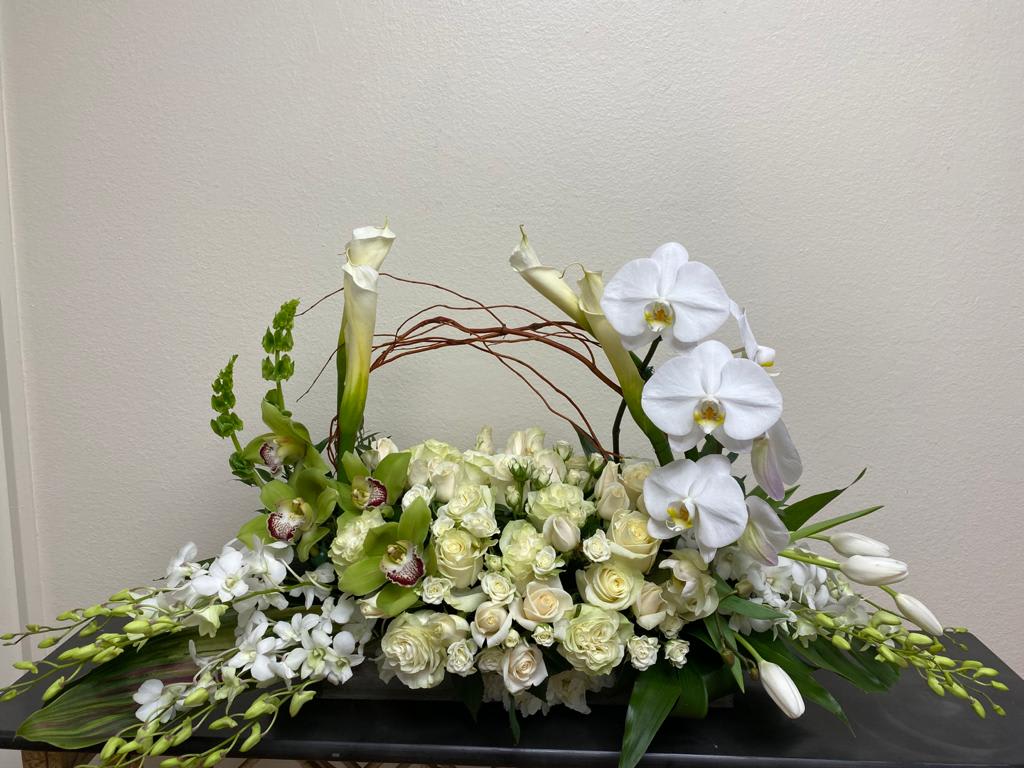 White floral arrangement with orchids, roses, and calla lilies