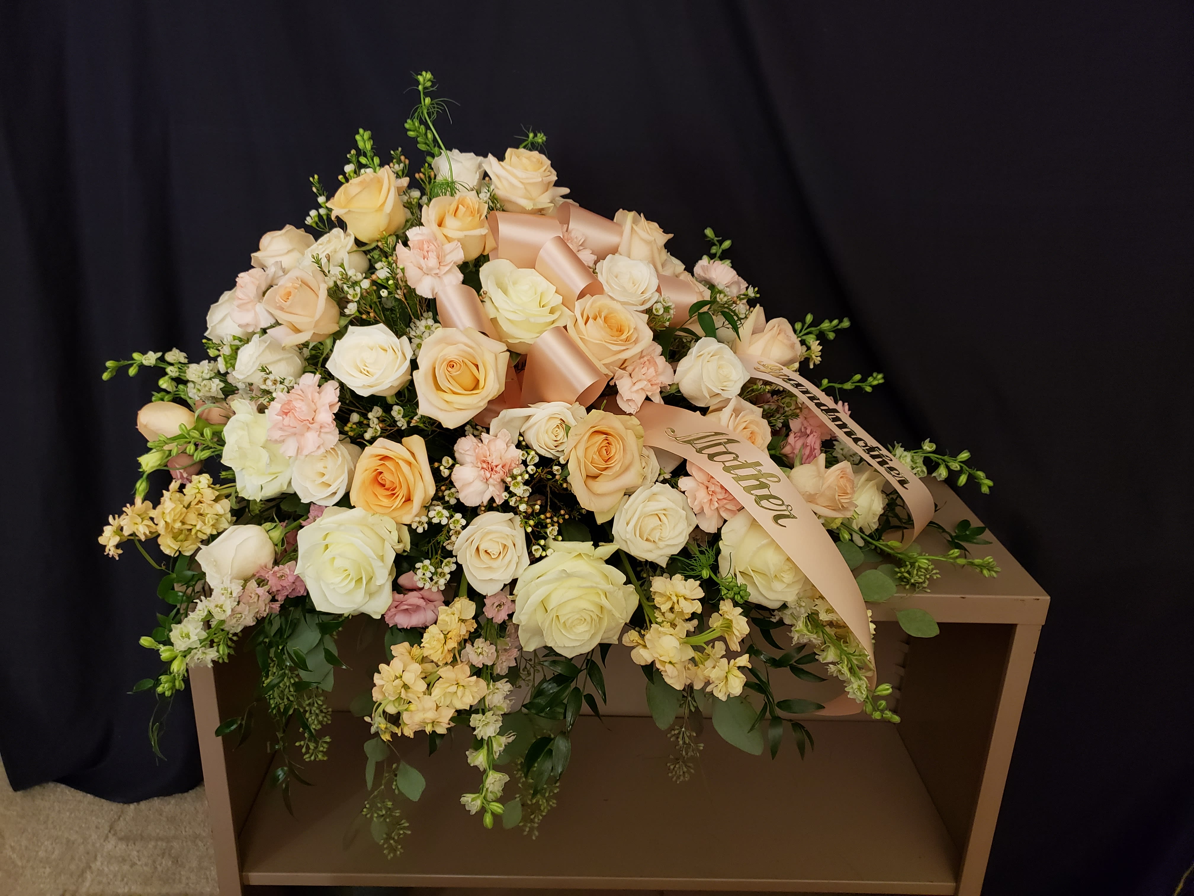 Large bouquet of cream and peach roses with ribbon on a box