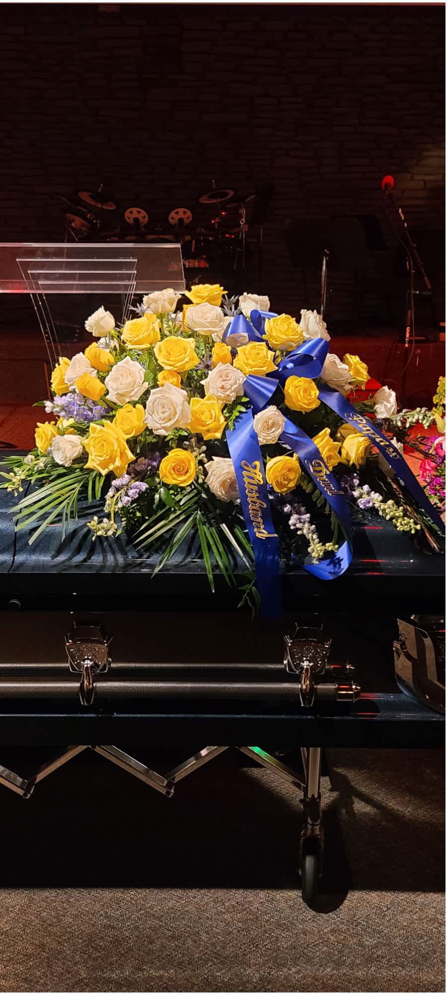 Peaceful Reflections Spray  - Creamy Roses, golden roses, and lush blue delphinium reflect the love we will hold in our spirit forever for those we hold so dear. 
