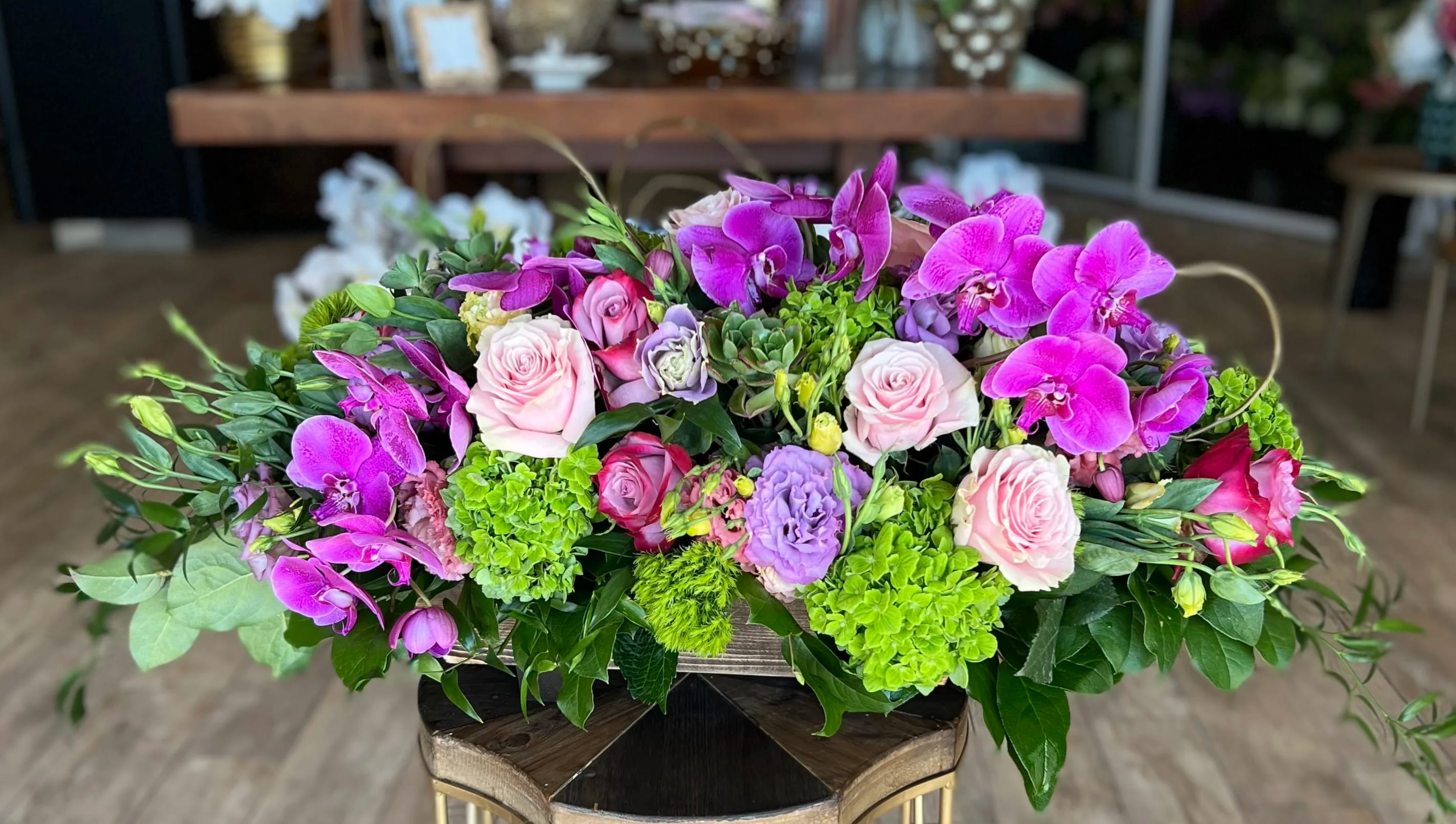 Pink roses and purple orchids in a low floral arrangement