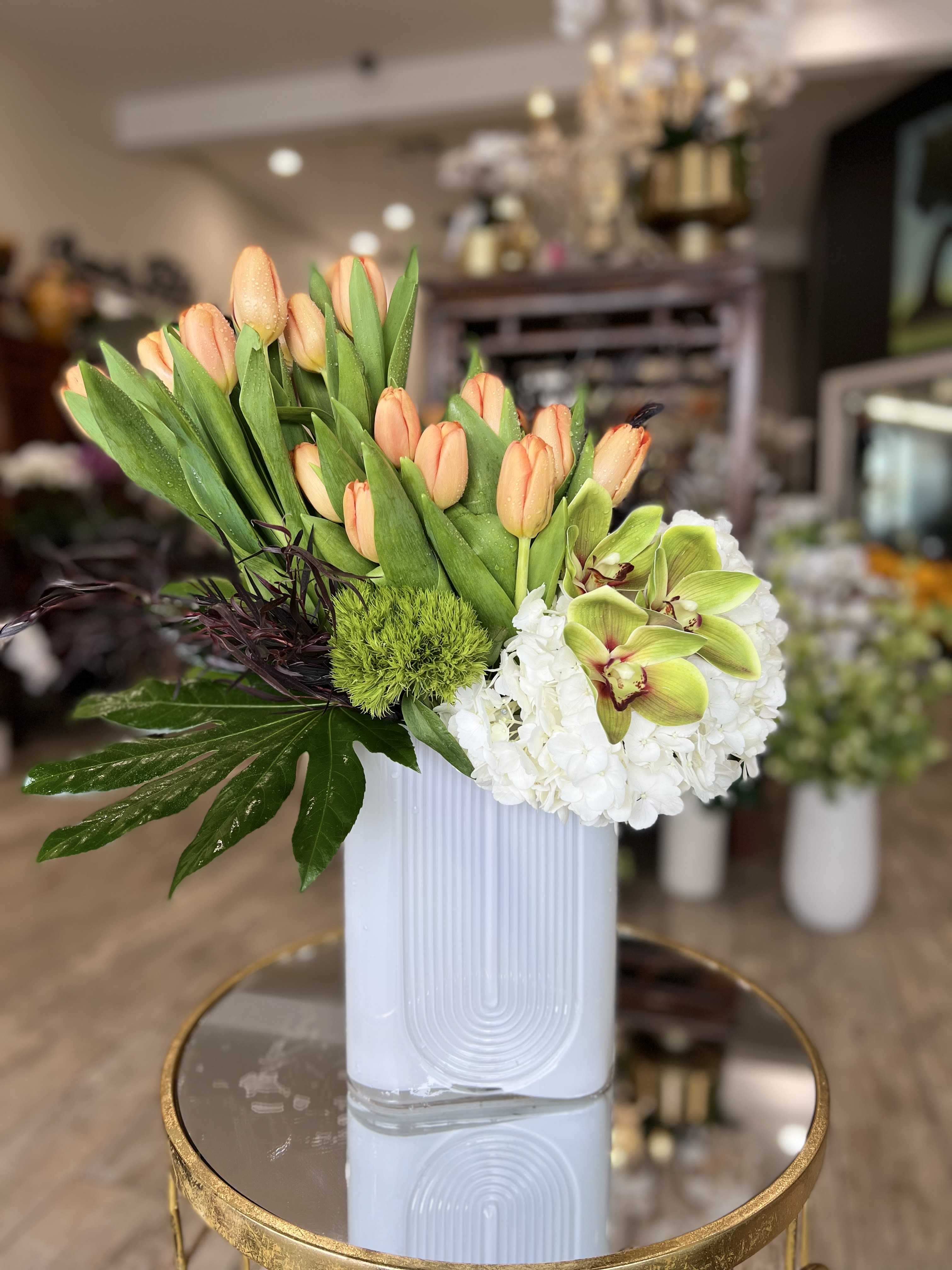 Peach tulips and white hydrangeas in a white vase