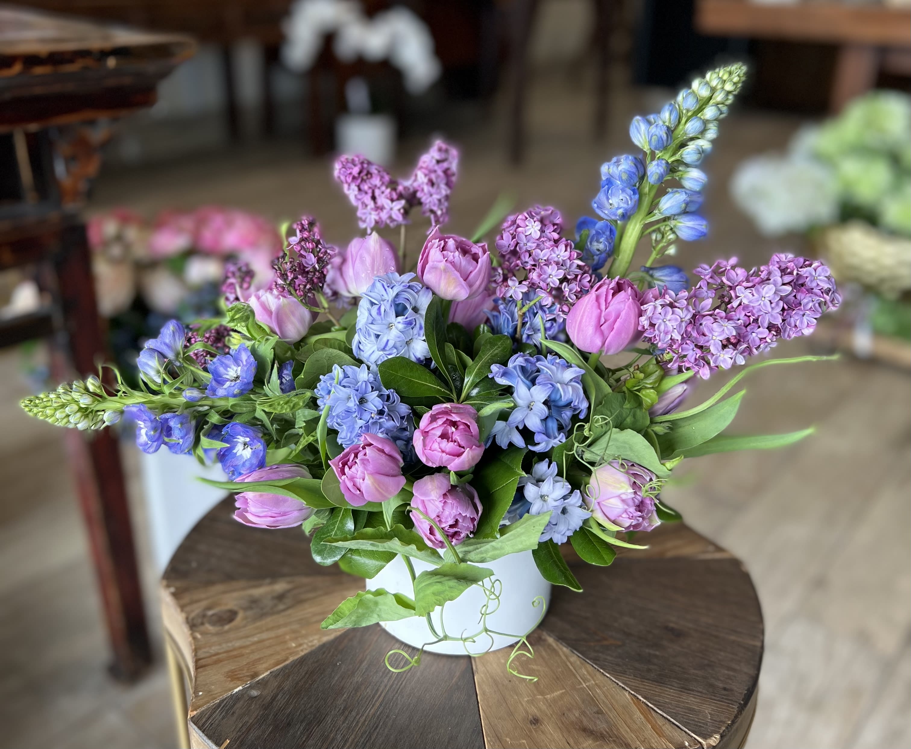Pink and blue mixed flowers arranged in a white vase