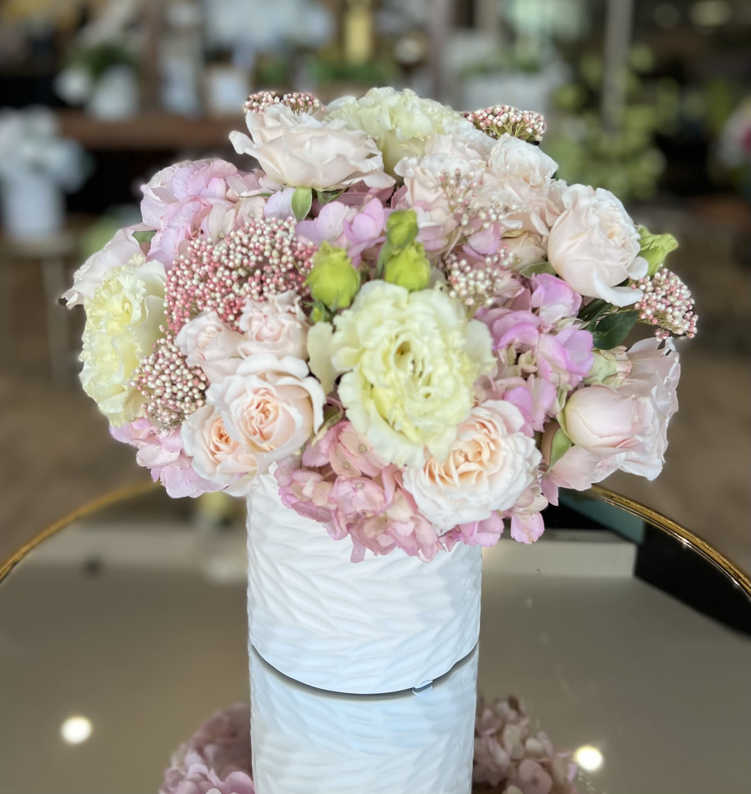 Pastel bouquet of roses and hydrangeas in a white vase