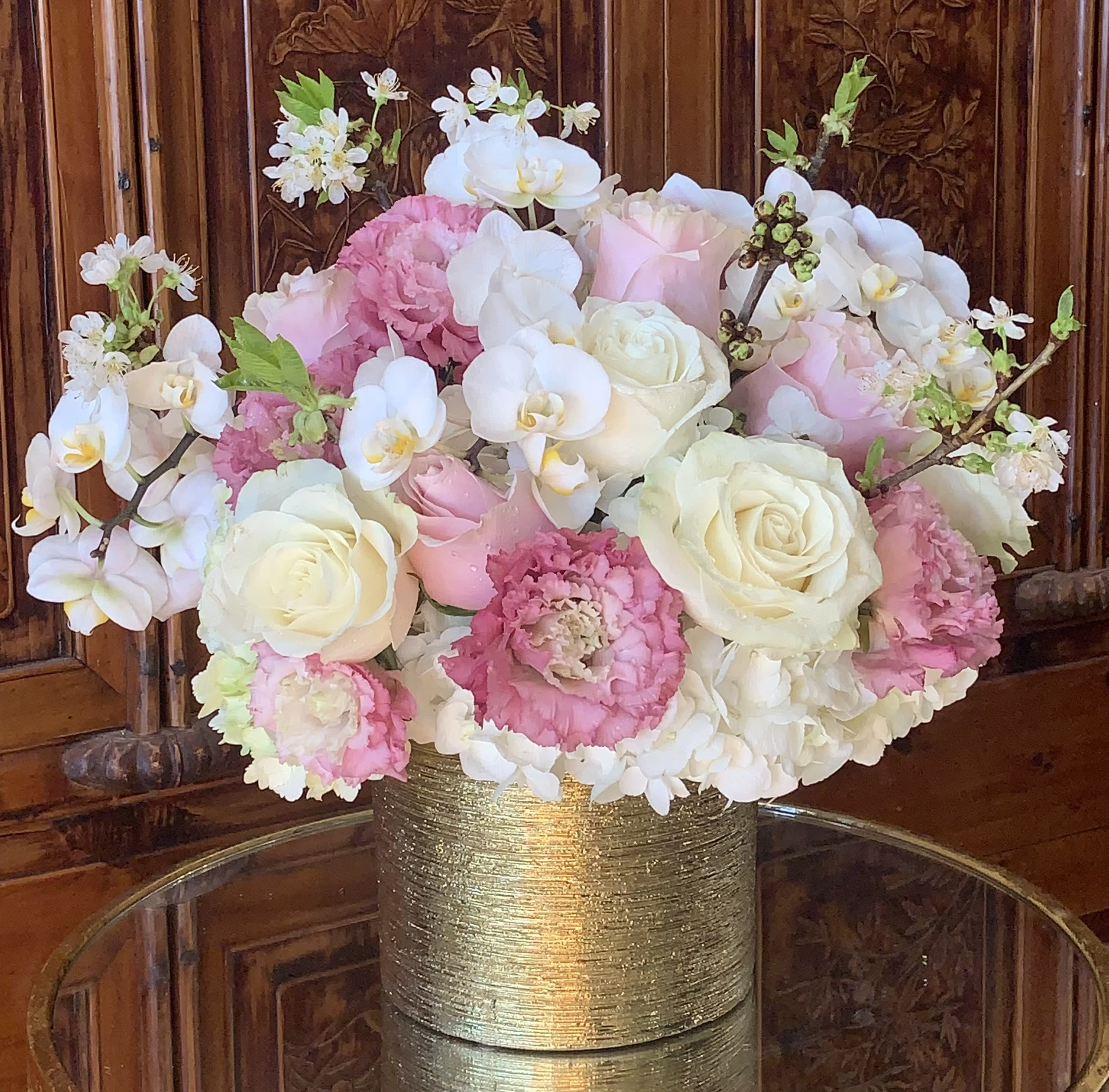 Pink and white floral arrangement in a gold vase