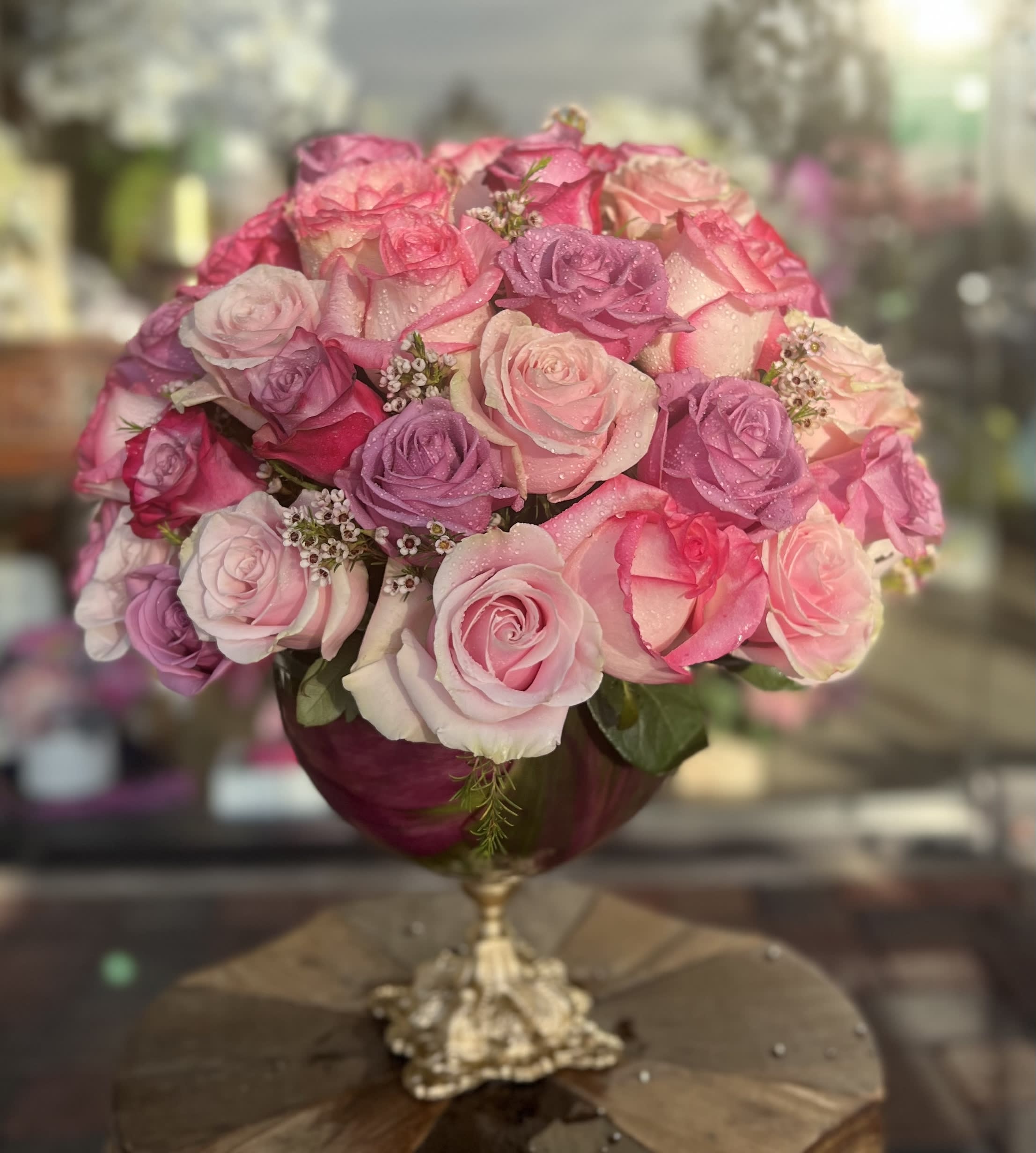 Pink and lavender rose bouquet in a gold pedestal vase