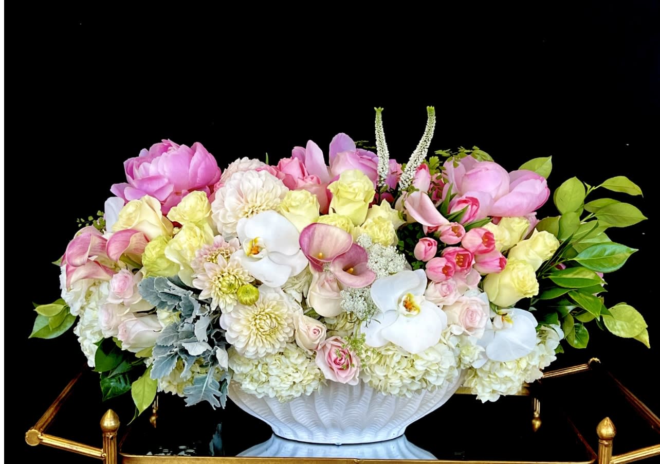 Large pastel floral arrangement in a white pedestal vase