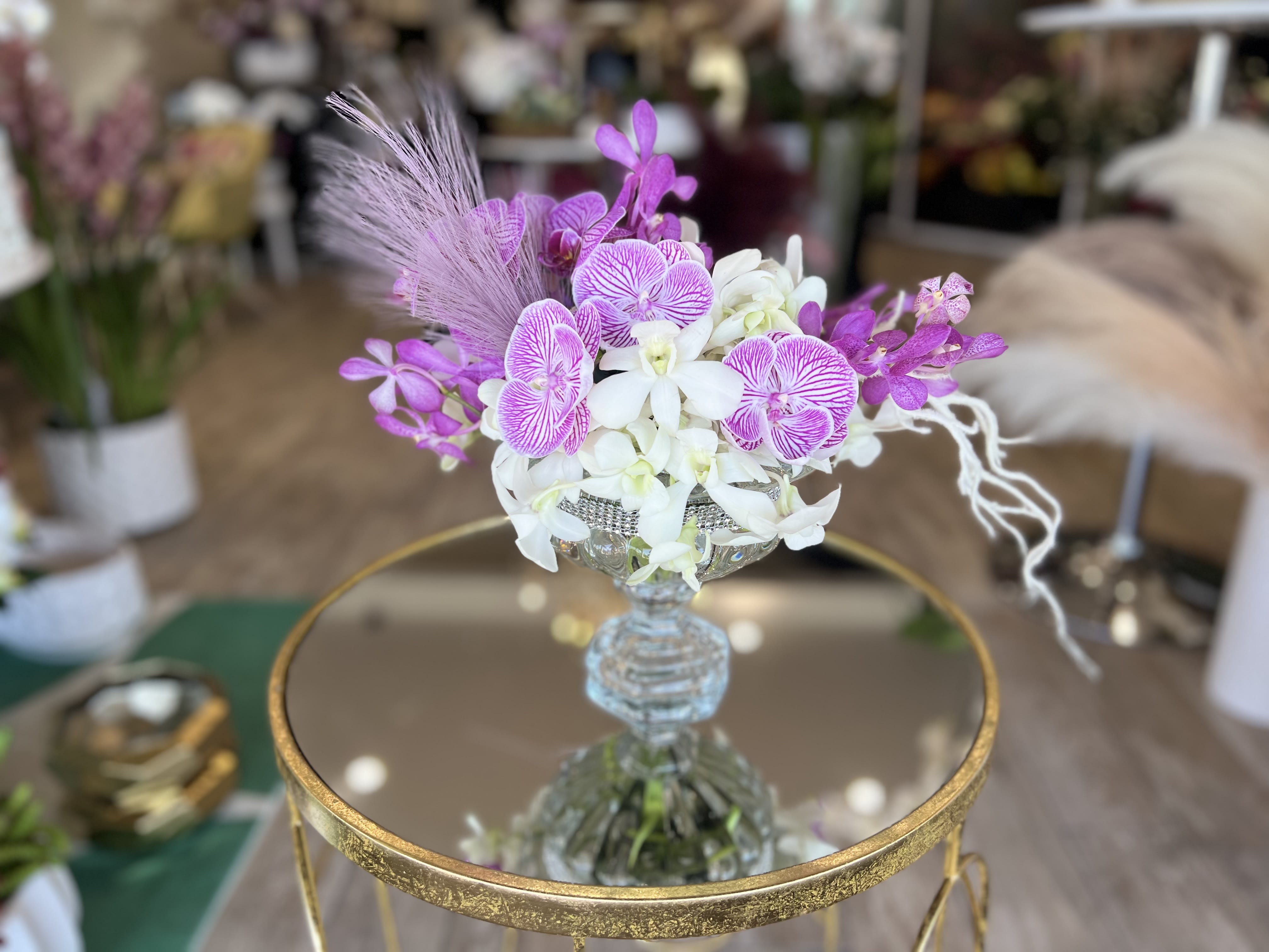 Purple and white orchid arrangement in a glass vase