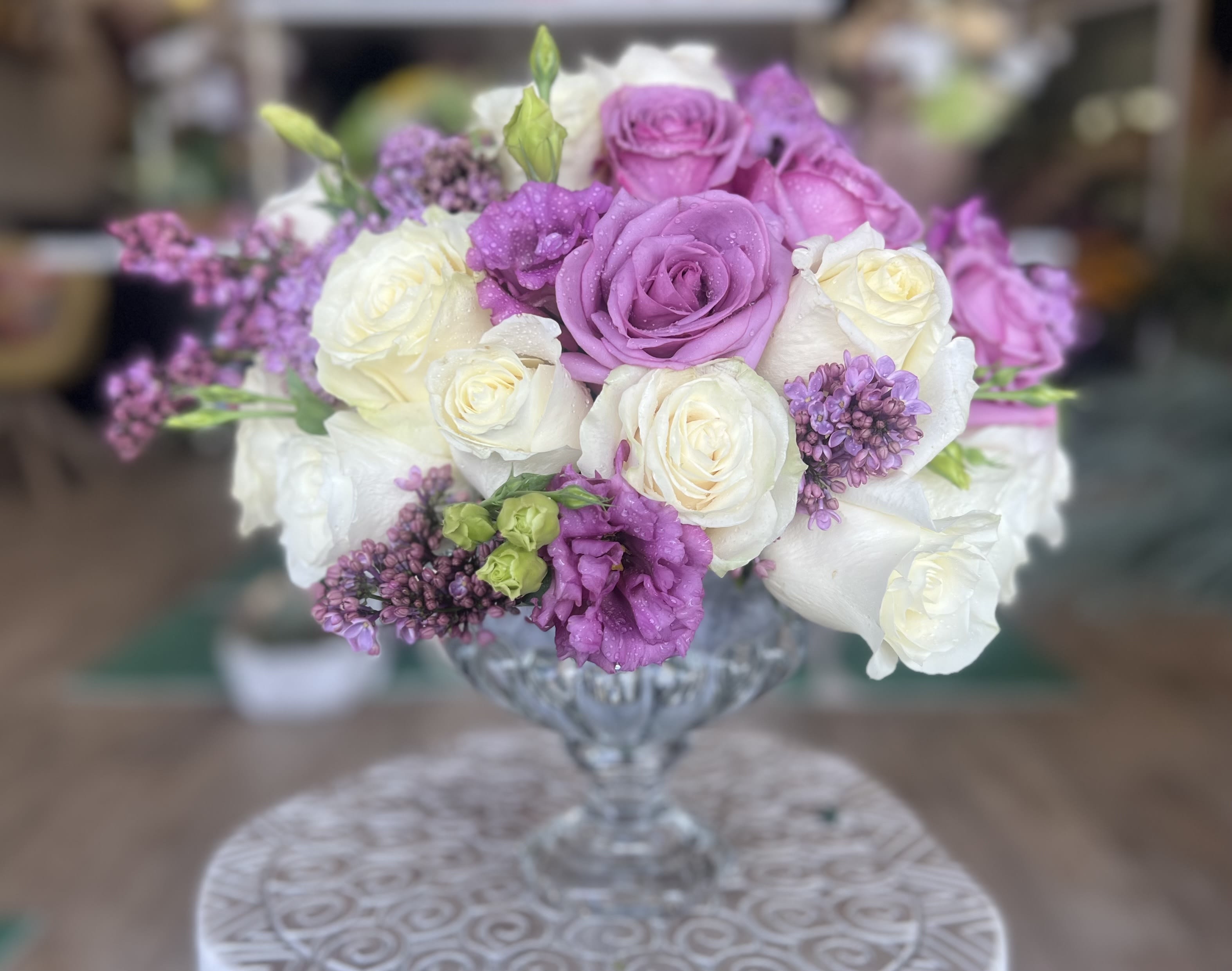 Lavender and white roses arranged in a clear glass vase