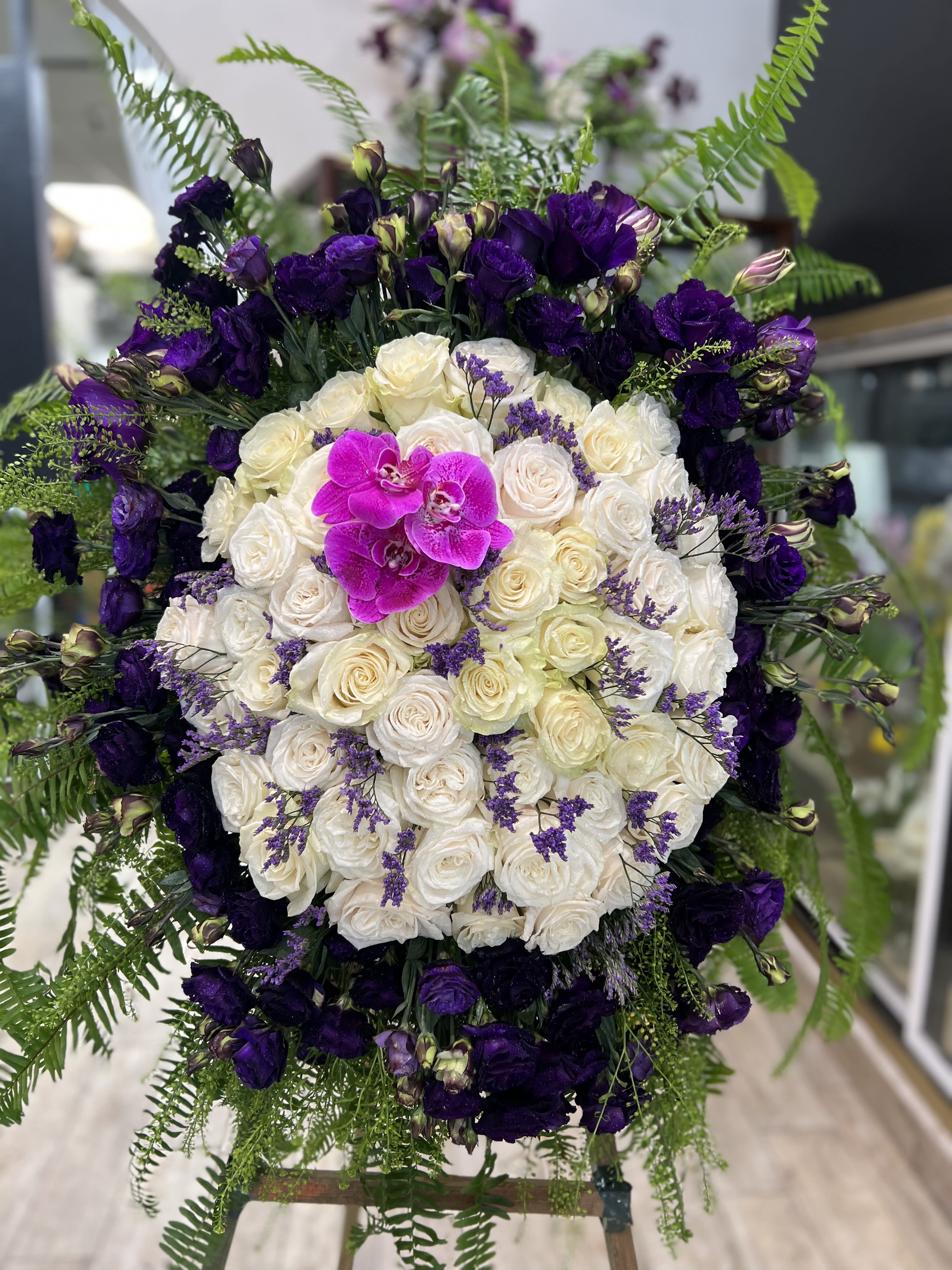 Large bouquet of white and purple roses with a bright pink orchid center