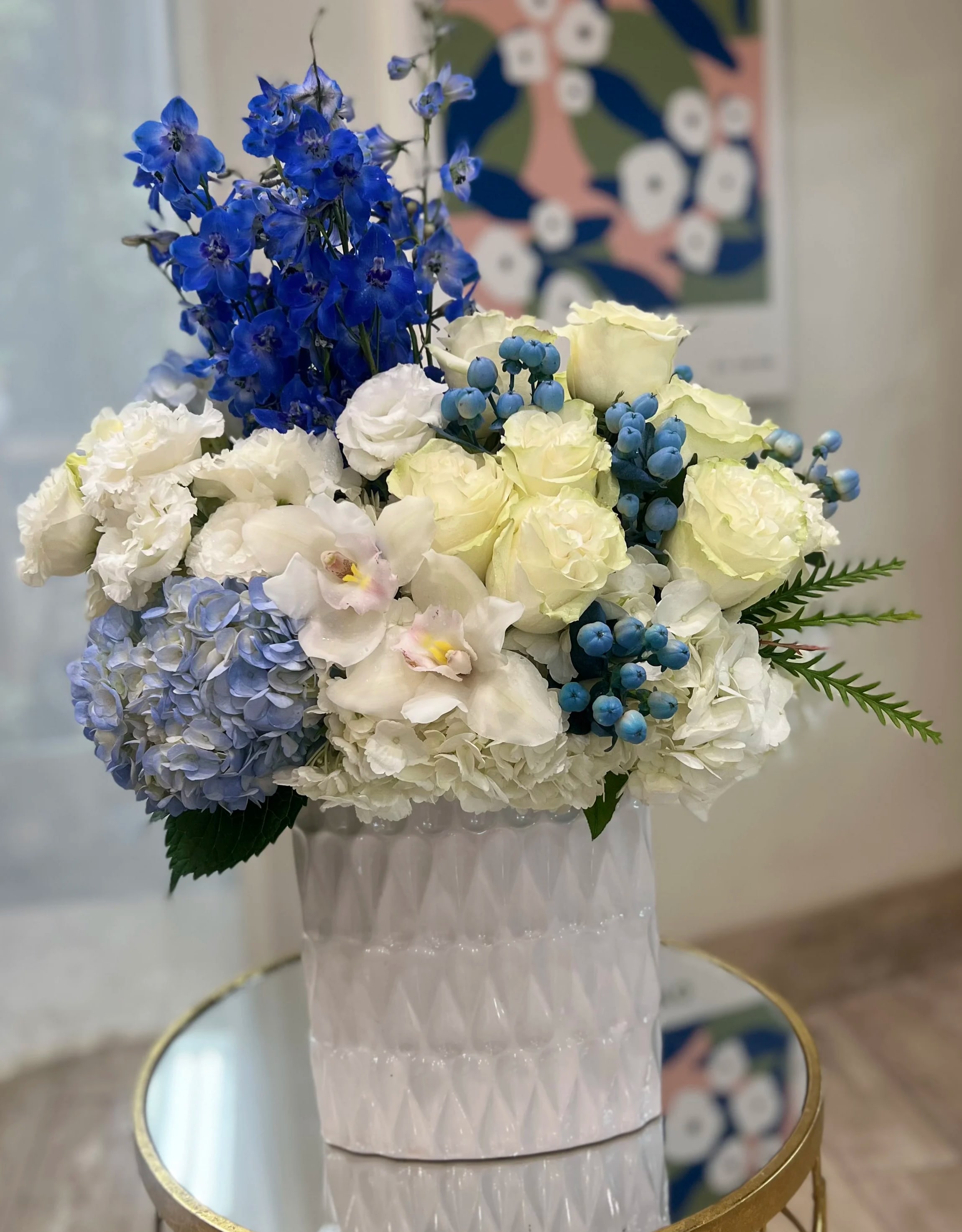Blue and white floral arrangement in a white vase